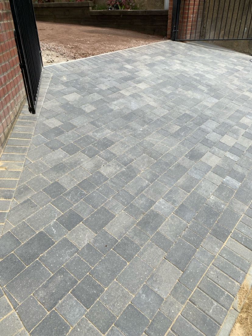 Herringbone pattern block paving driveway in grey tones